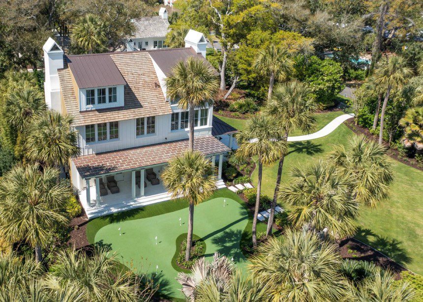 A house with palm trees and a golf course.